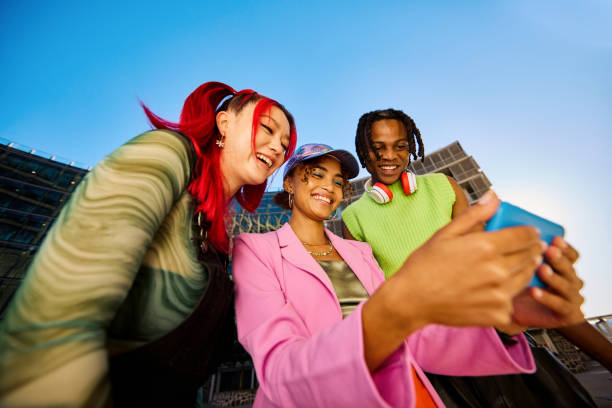 Three women taking a selfie together outdoors on a clear day.